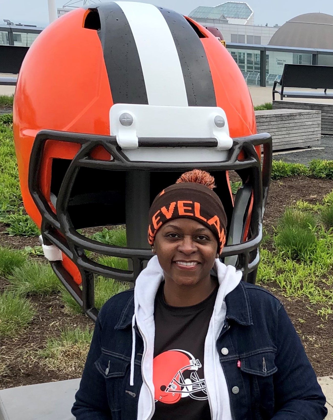 photo of Adrienne in a winter hat in front of a large Cleveland browns helmet